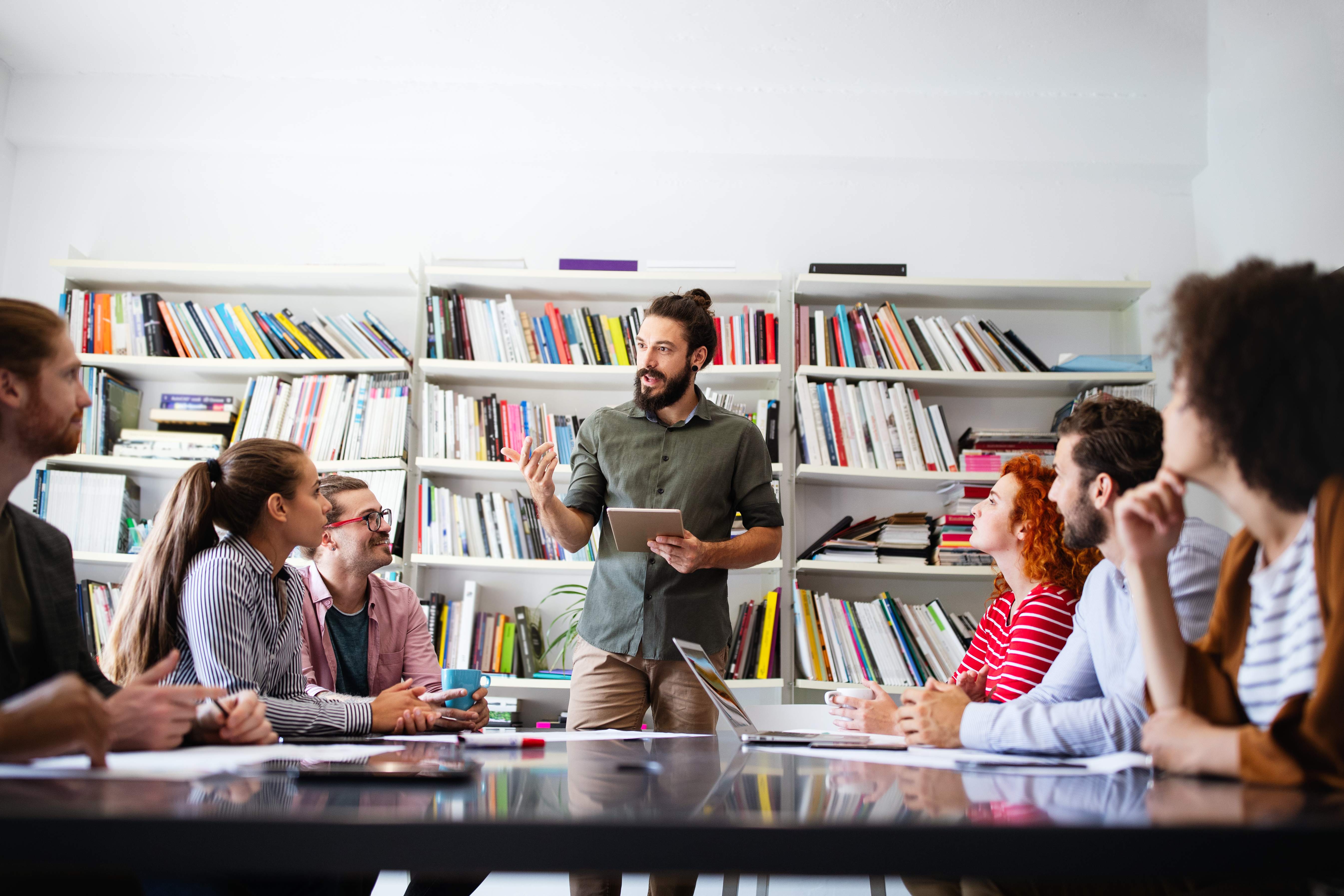 Equipe de trabalho em ambiente com mesa e livros