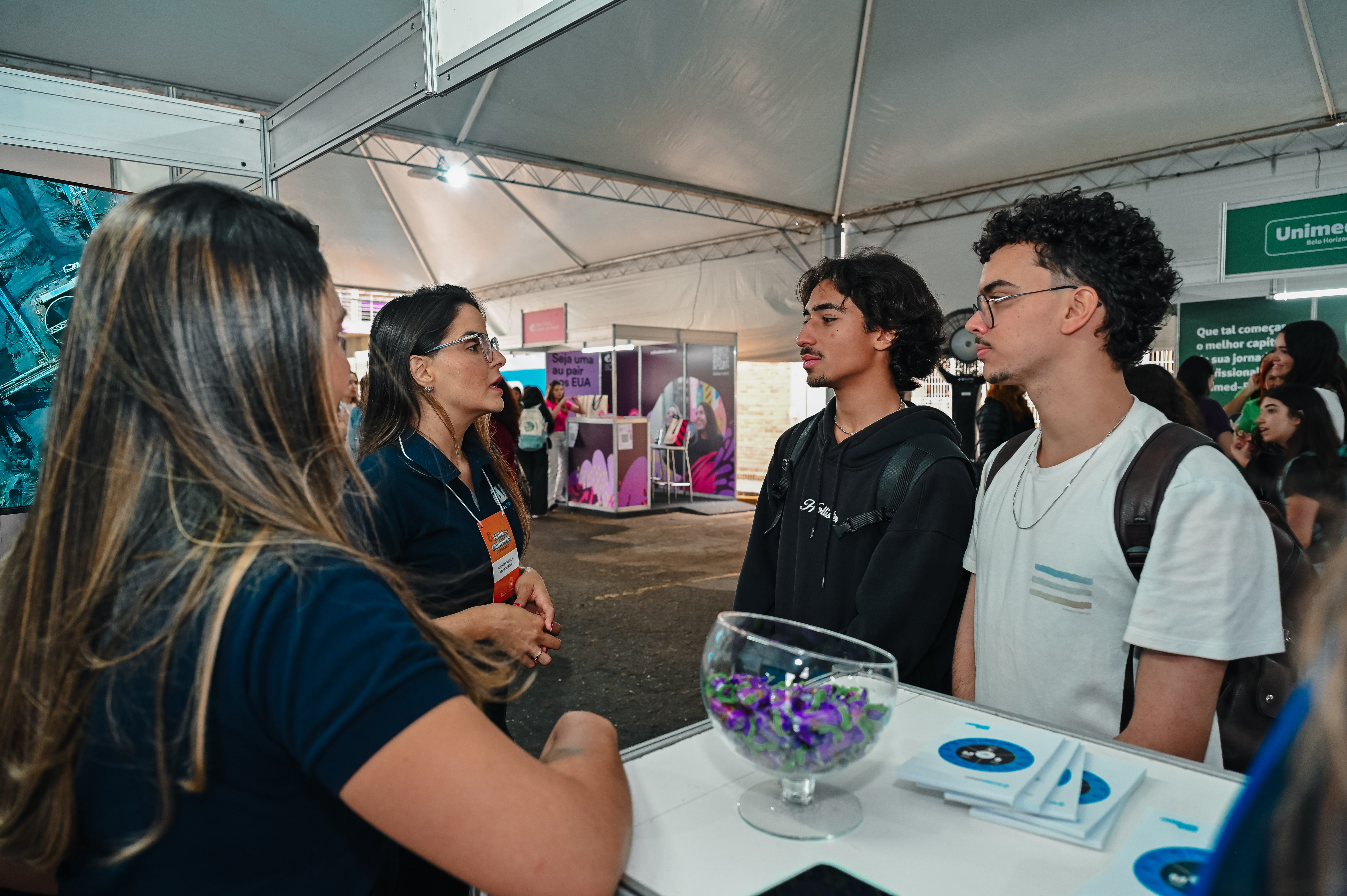 Dois alunos interagindo com expositores 