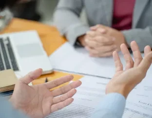 Detalhe de mãos de pessoas conversando em ambiente de escritório