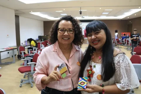 Professora Evanilde, diretora da PUC Carreiras e Andreza dos Santos, aluna da pós-graduação, mostram suas obras