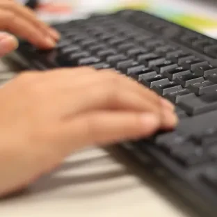 Mulher digitando em teclado de computador