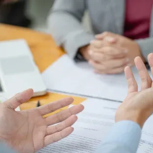 Detalhe de mãos de pessoas conversando em ambiente de escritório